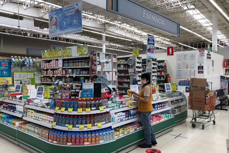 mujer con cubrebocas en el área de farmacia de uno de los supermercados
