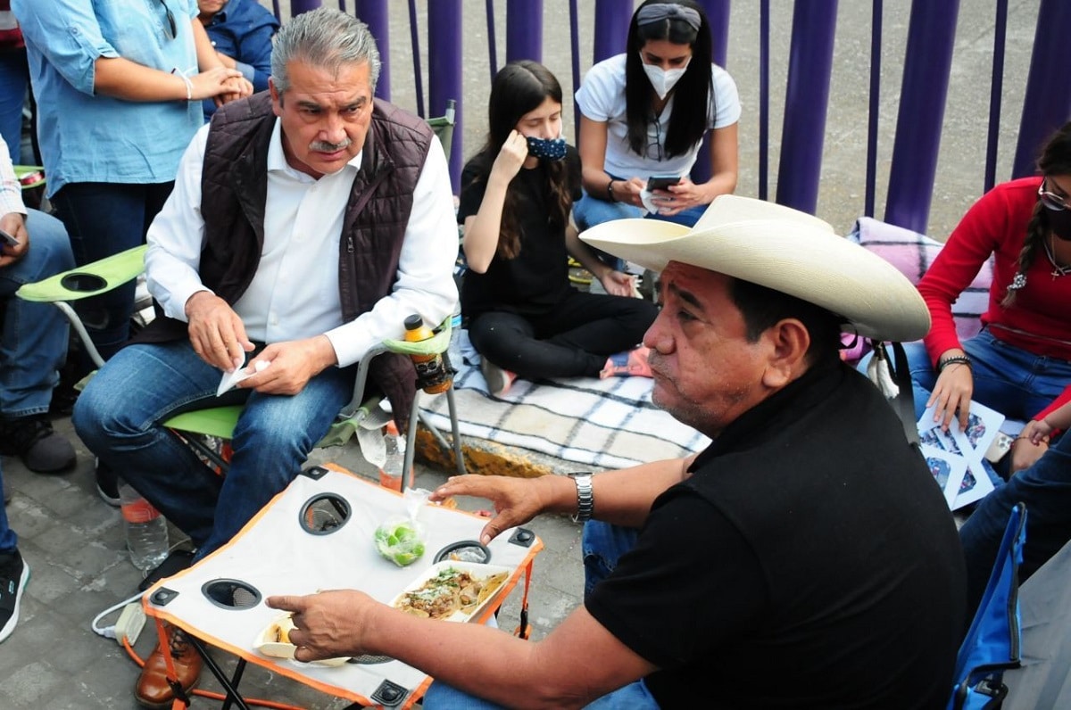 Raúl Morón y Félix Salgado Macedonio, comen durante el plantón afuera de las instalaciones del INE