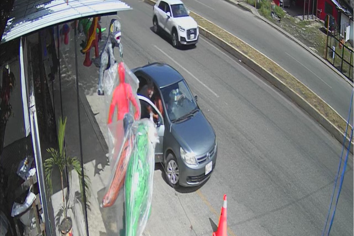 Foto: redes | En el clip, un hombre desciende de un auto para llevarse una de las piñatas.