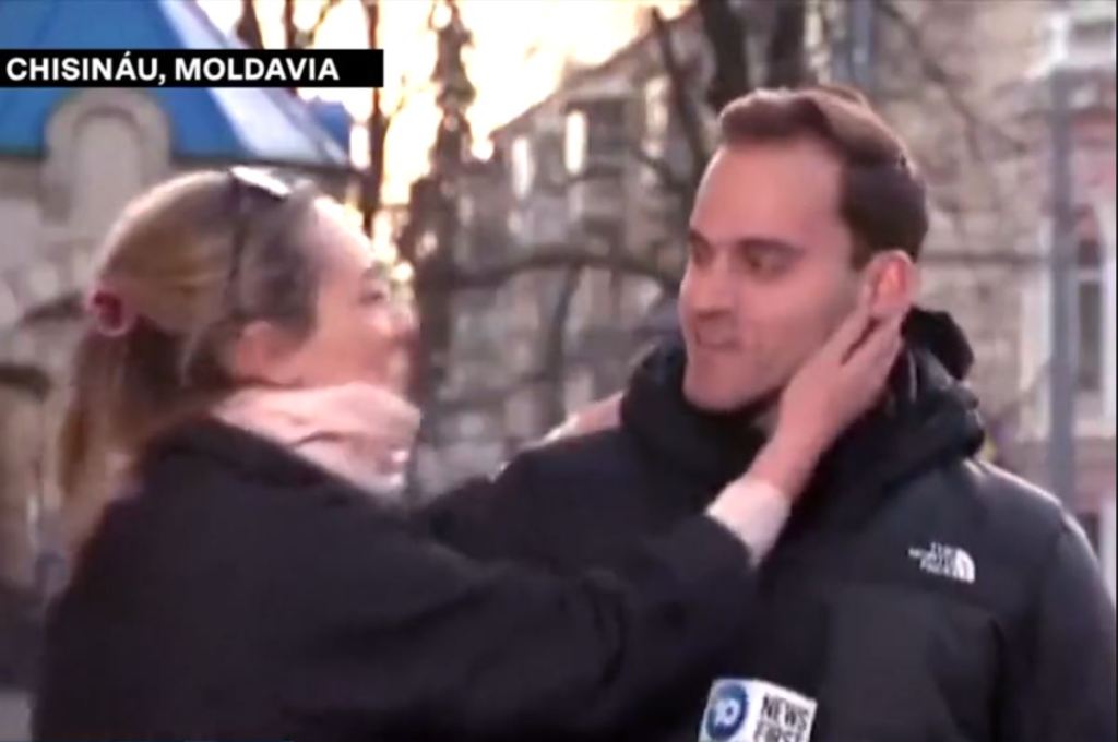 Mujer interrumpe enlace de reportero para darle un beso.
