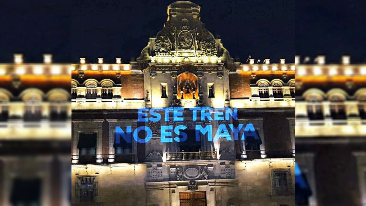 Foto: @VotoXel | Proyectan mensajes de protesta contra el Tren Maya, en Palacio Nacional.