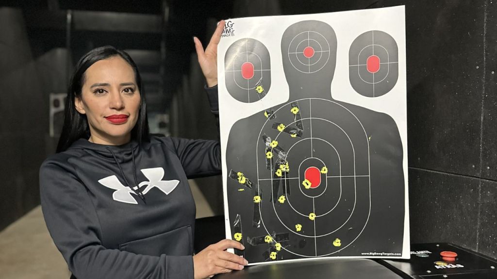 Sandra Cuevas presume manejo de arma en práctica de tiro.