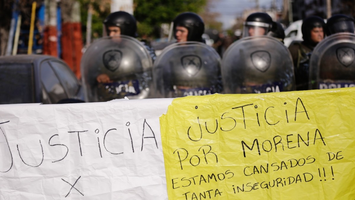 Habitantes portaron pancartas ayer con la leyenda "Justicia para Morena, estamos cansados de tanta inseguridad" mientras policías hacen guardia durante una manifestación en Lanús