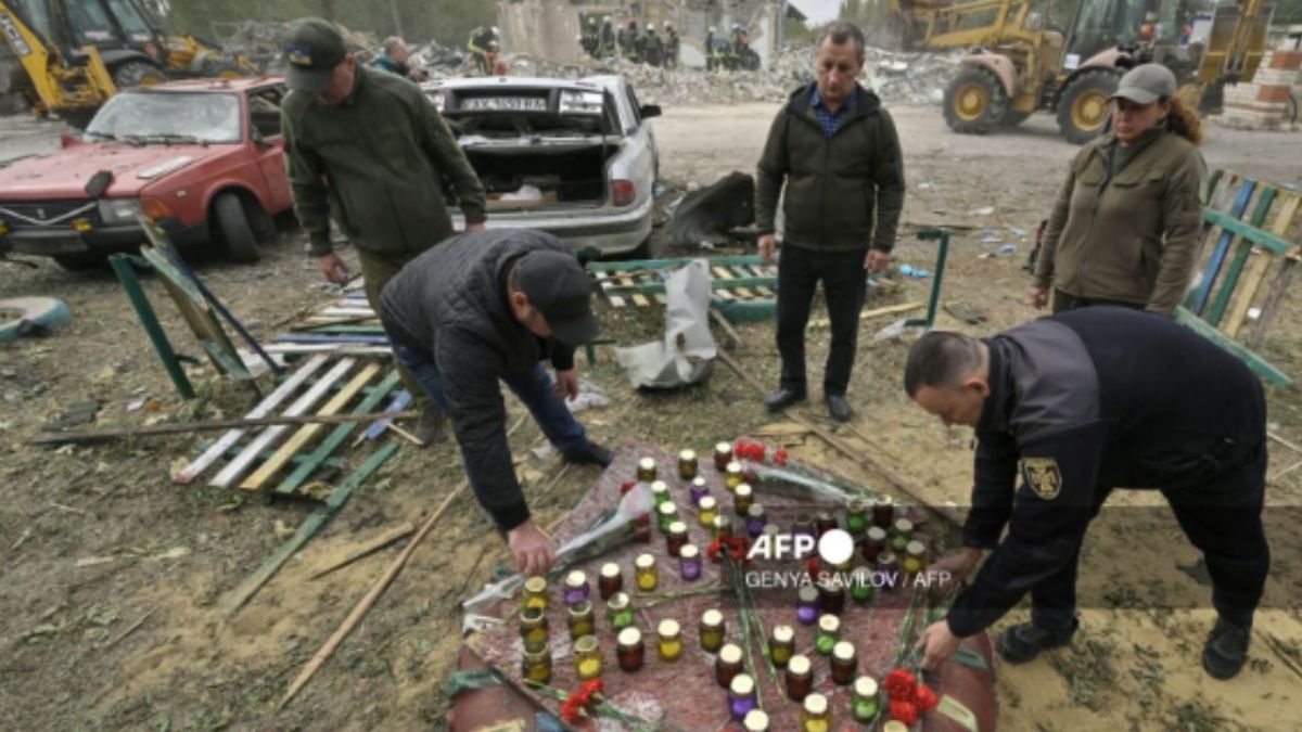 La gente deposita flores y enciende velas mientras los rescatistas ucranianos trabajan para retirar los escombros tras un ataque ruso que dejó al menos 51 muertos