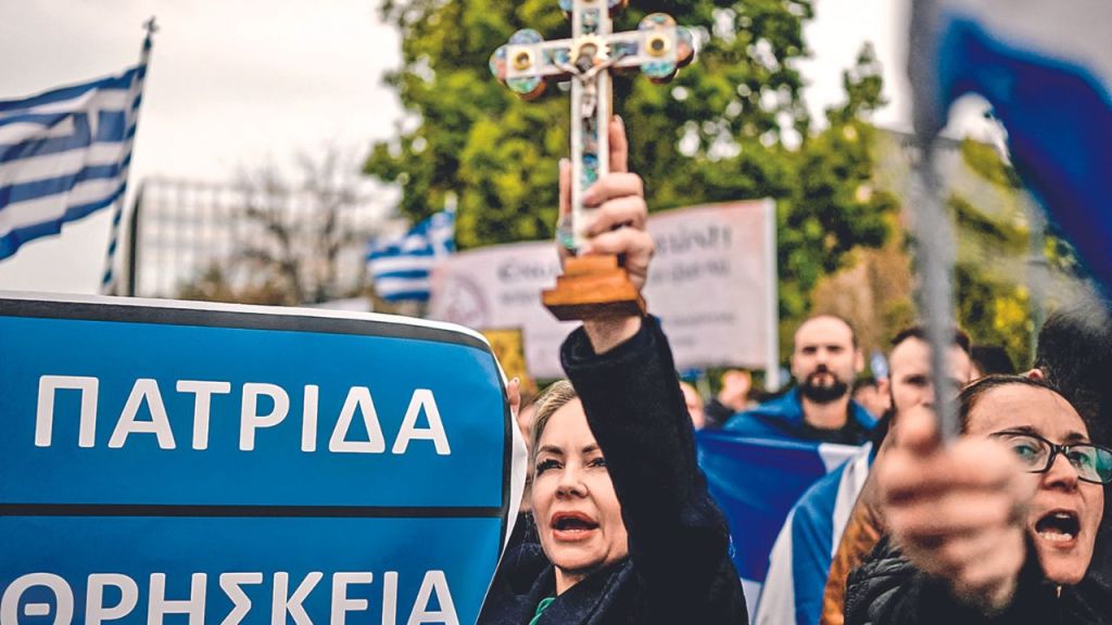 RECHAZO. Una manifestante levantó ayer una cruz en la plaza Síntagma, en Atenas, para mostrar su postura contra una reforma que legaliza el matrimonio y la adopción homosexuales, que será debatida por el Parlamento de Grecia en la próxima semana.