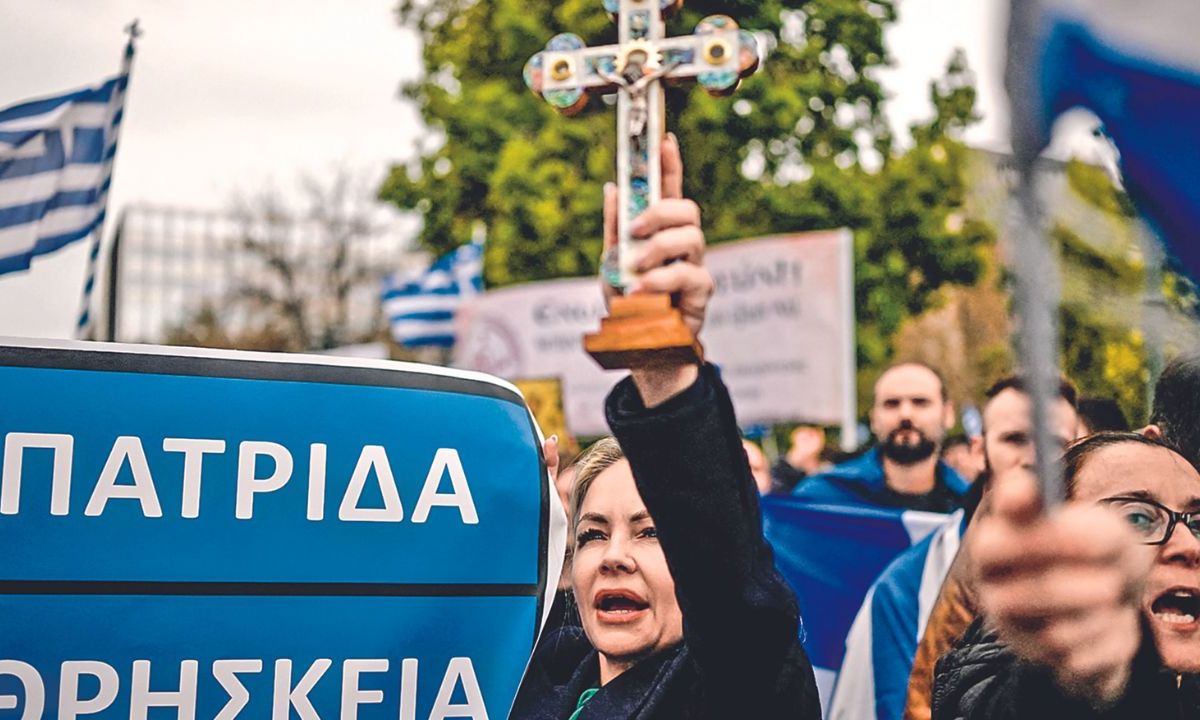 RECHAZO. Una manifestante levantó ayer una cruz en la plaza Síntagma, en Atenas, para mostrar su postura contra una reforma que legaliza el matrimonio y la adopción homosexuales, que será debatida por el Parlamento de Grecia en la próxima semana.