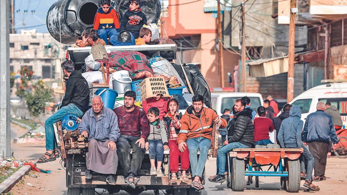 RETORNO. Miembros de una familia palestina huyeron ayer de Rafah en la parte trasera de un camión con sus pertenencias, hacia el centro de la Franja de Gaza.