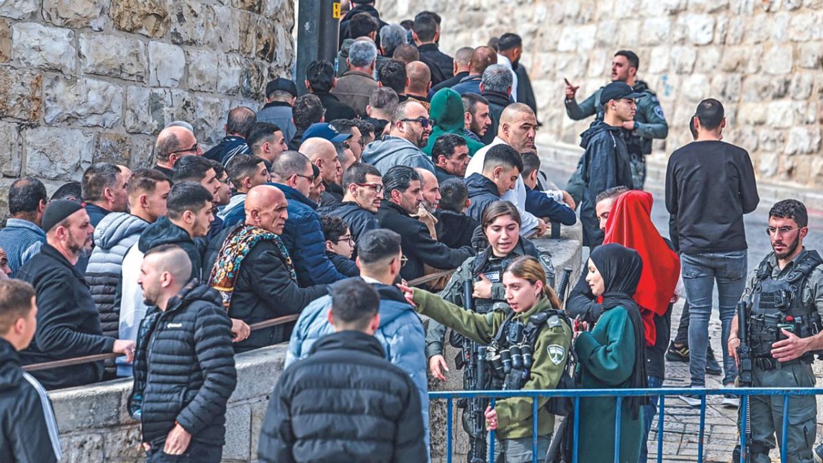BLOQUEO. Miembros de las fuerzas de seguridad israelíes montaban guardia mientras musulmanes esperaban cerca de la Puerta del León para entrar a la mezquita de Al Aqsa antes de la oración del mediodía.