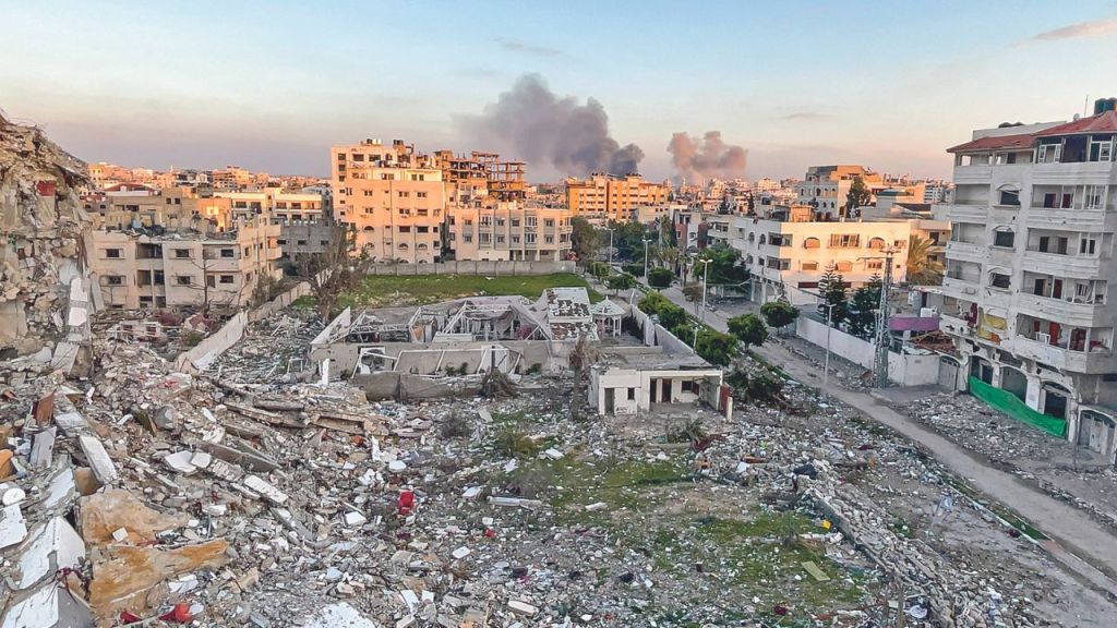 ATAQUE. Los escombros de edificios destruidos y humo se visualizaban ayer durante un bombardeo en la Franja, en medio de los combates entre Israel y Hamás.