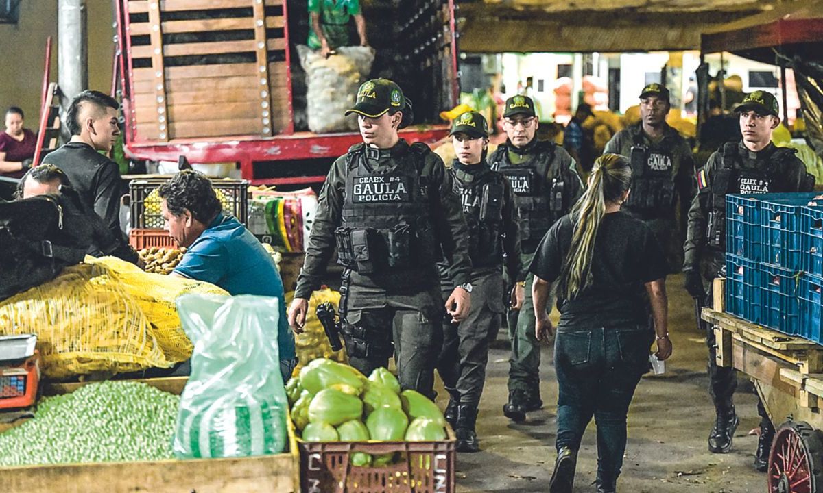 POLICÍA. Miembros del Gaula (Grupos de Acción Unificada por la Libertad Personal) patrullaban el mercado de Santa Helena durante una campaña para evitar la extorsión en Cali, el 17 de febrero de 2024.