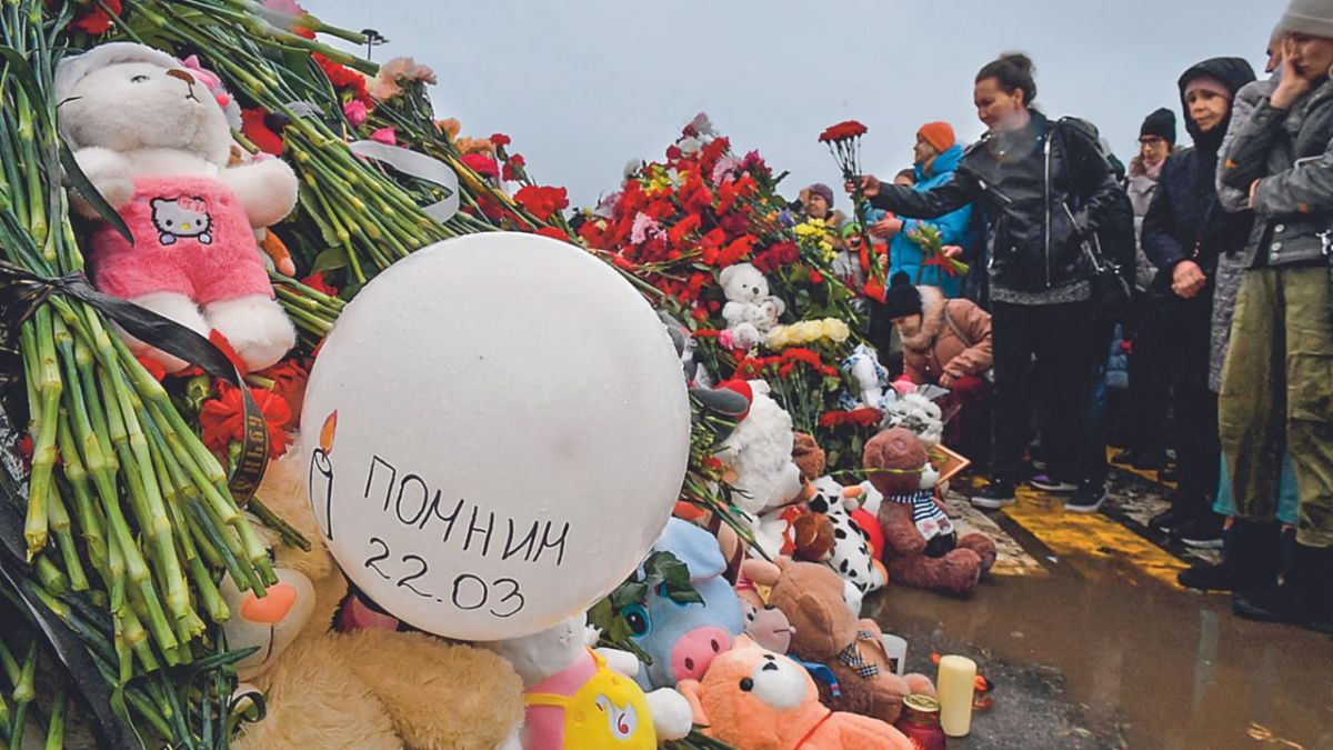 DUELO. Un grupo de personas depositó ayer flores y muñecos en una localidad de Moscú.