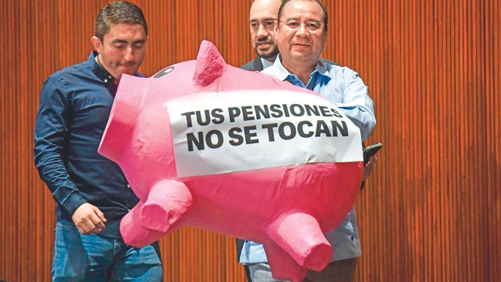 Protesta. Roberto Valenzuela, diputado del PAN, carga un "cochinito" de cartón durante la sesión ordinaria semipresencial de la Cámara de Diputados
