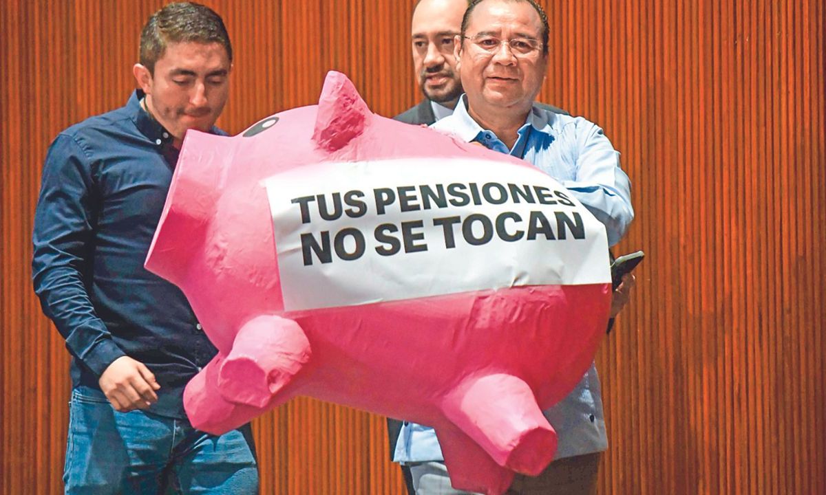 Protesta. Roberto Valenzuela, diputado del PAN, carga un "cochinito" de cartón durante la sesión ordinaria semipresencial de la Cámara de Diputados