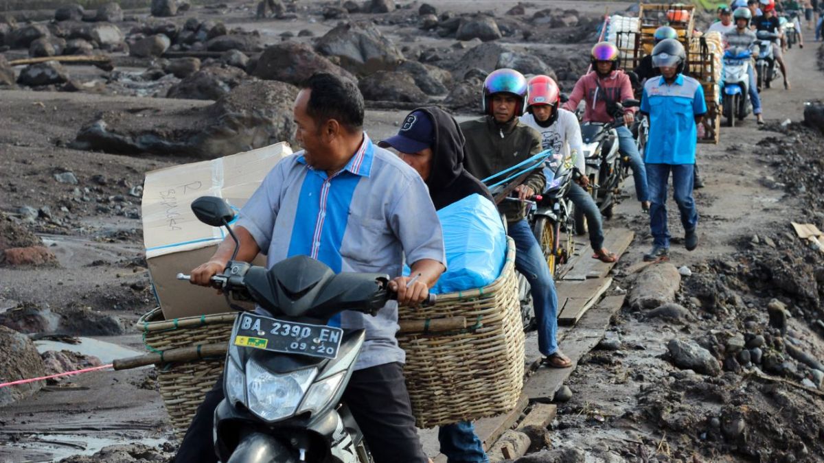 ERUPCIÓN. Los habitantes evacuaron ayer por un camino improvisado en Tanah Datar, Sumatra Occidental, mientras monte Merapi arrojó lava sobre sus laderas.