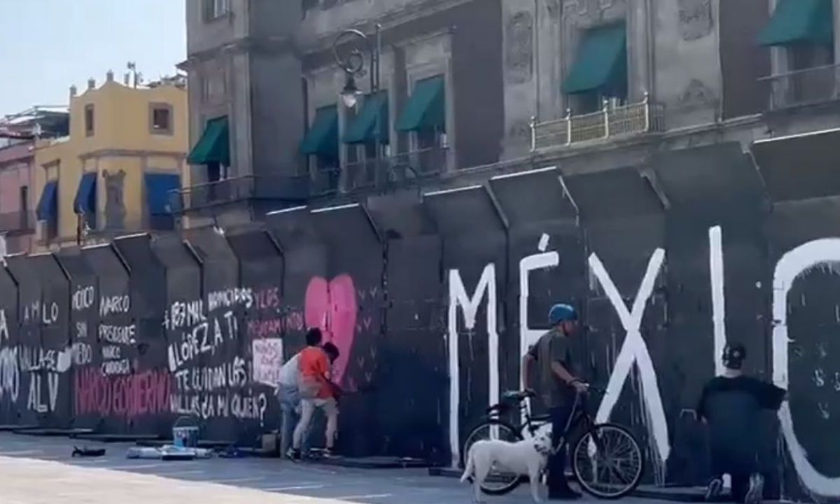 Con frases como "México merece más” o “Voto libre”, jóvenes pintan vallas de Palacio Nacional previo a la marcha de la Marea Rosa